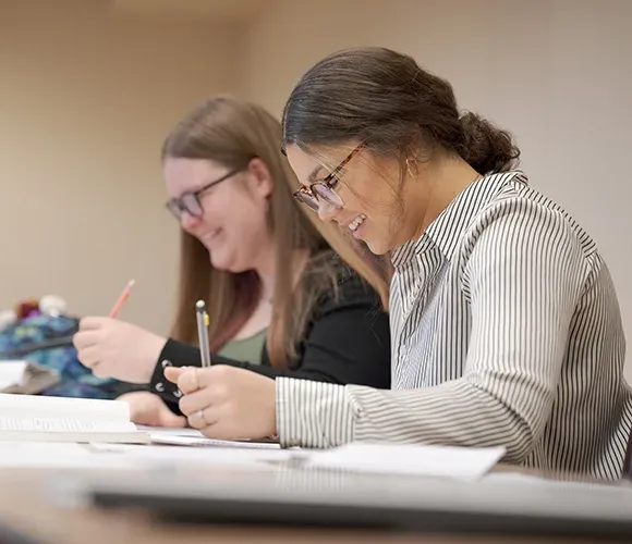 Two students working on papers